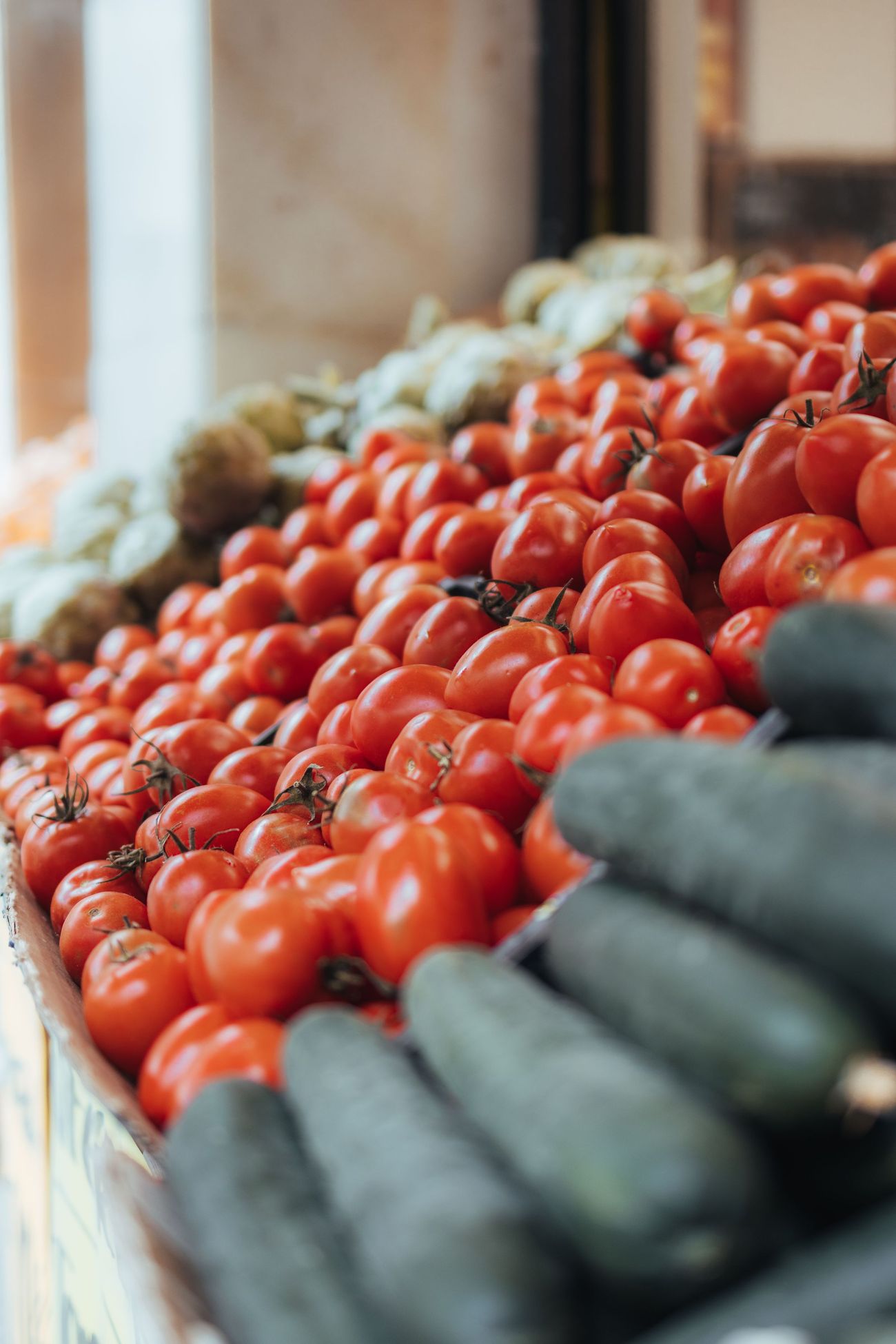 Crates of tomatoes and cucumbers on a market stall, the week&rsquo;s produce as it actually looks