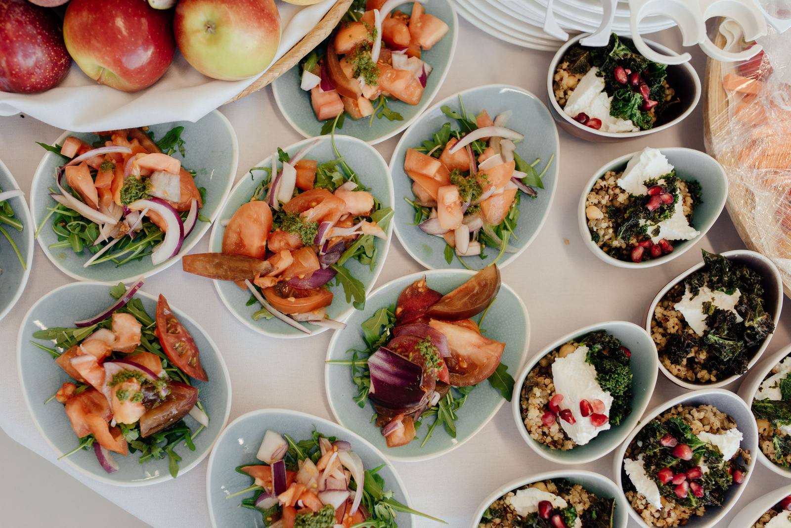Bowls of salad and ripe vegetables laid out from above, ready to be portioned