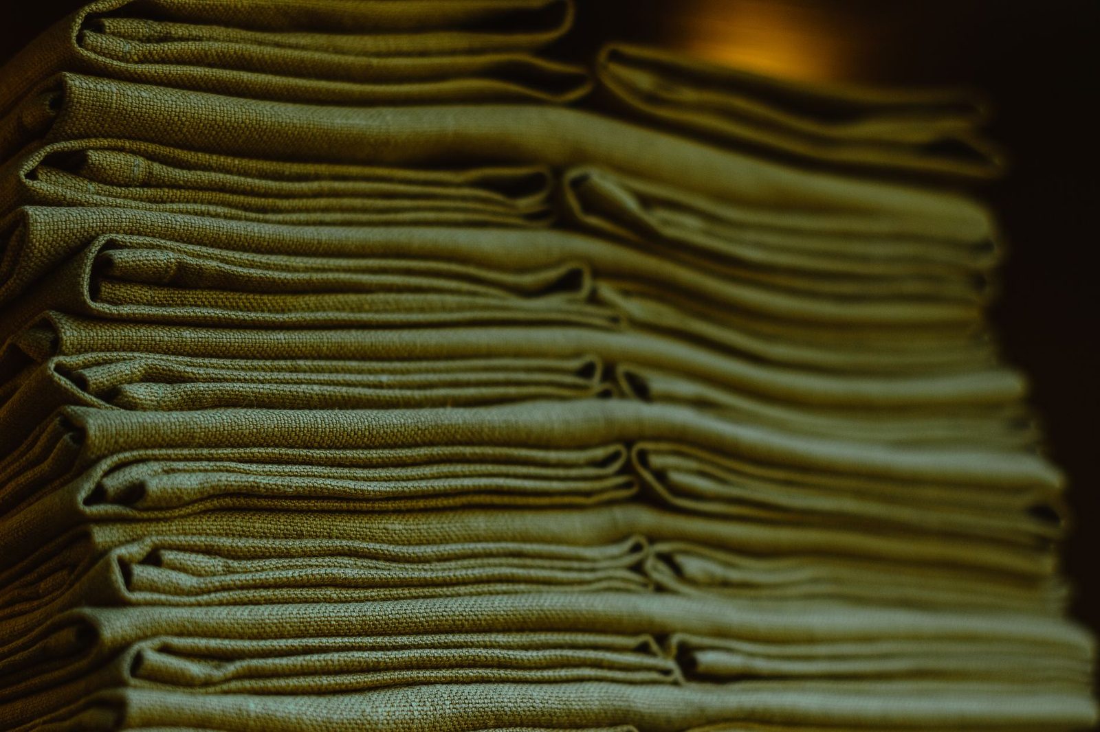 A close stack of neatly folded linens showing the texture of the cloth