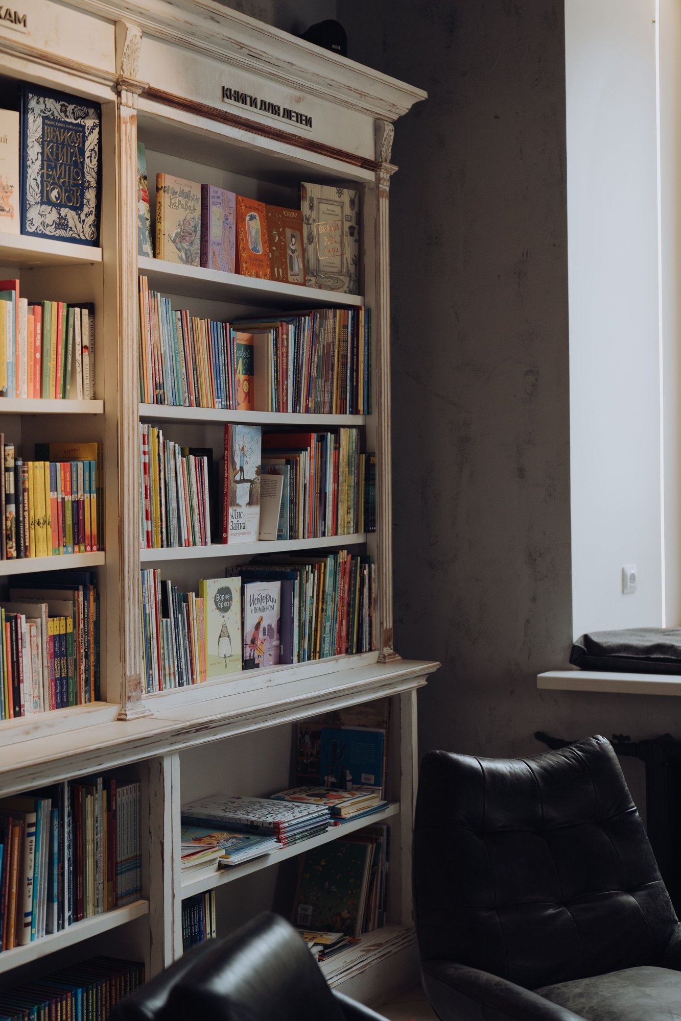 Floor-to-ceiling bookshelves in a quiet room with leather chairs.