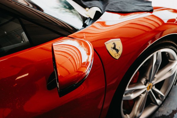 Sunlight reflecting off the polished red paintwork of a sports car