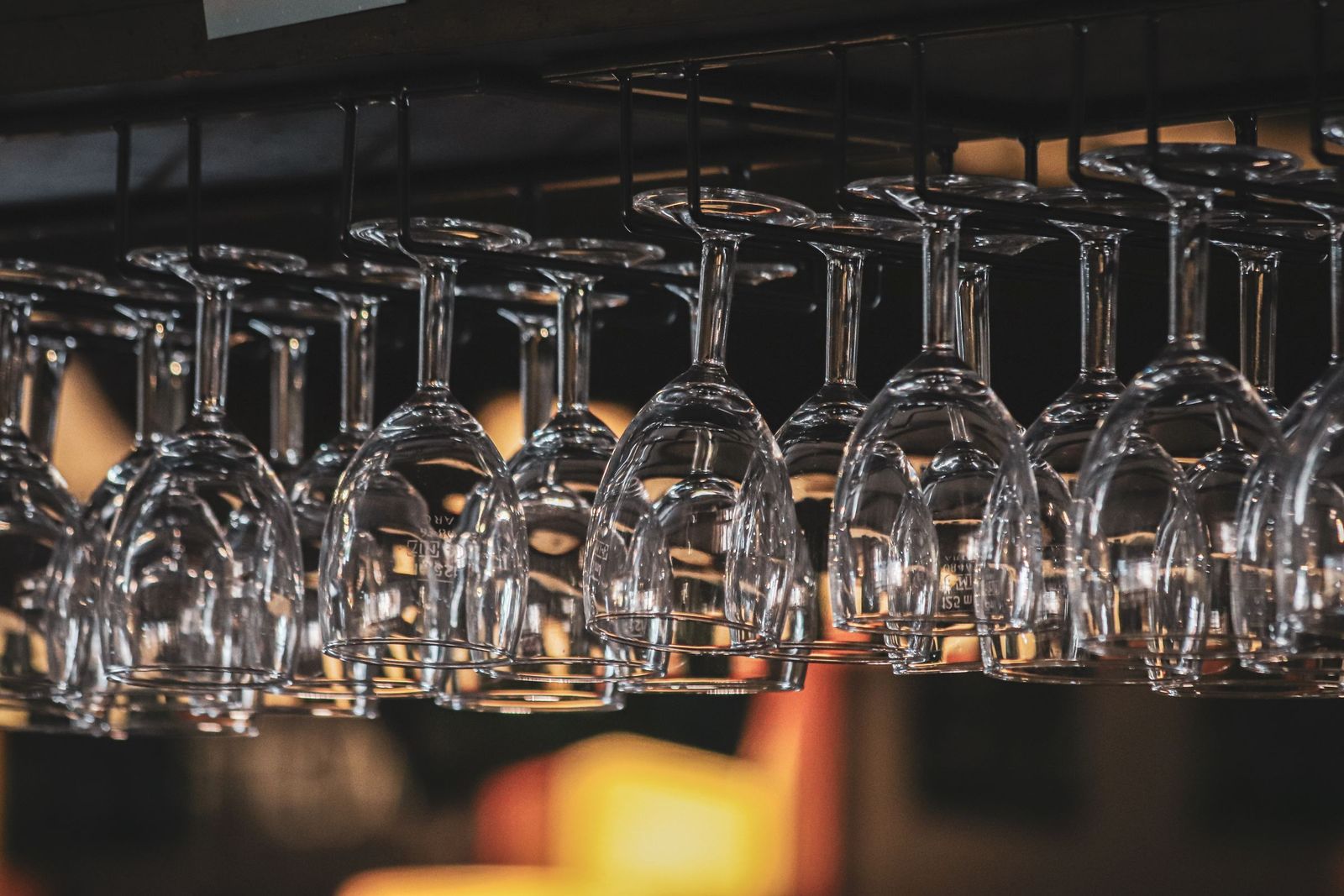 Rows of wine glasses hung upside down on a rack above the bar