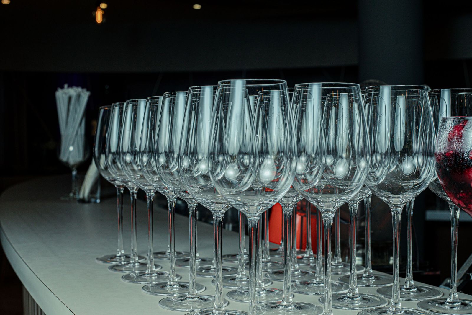 A line of empty glasses set out along the counter before service